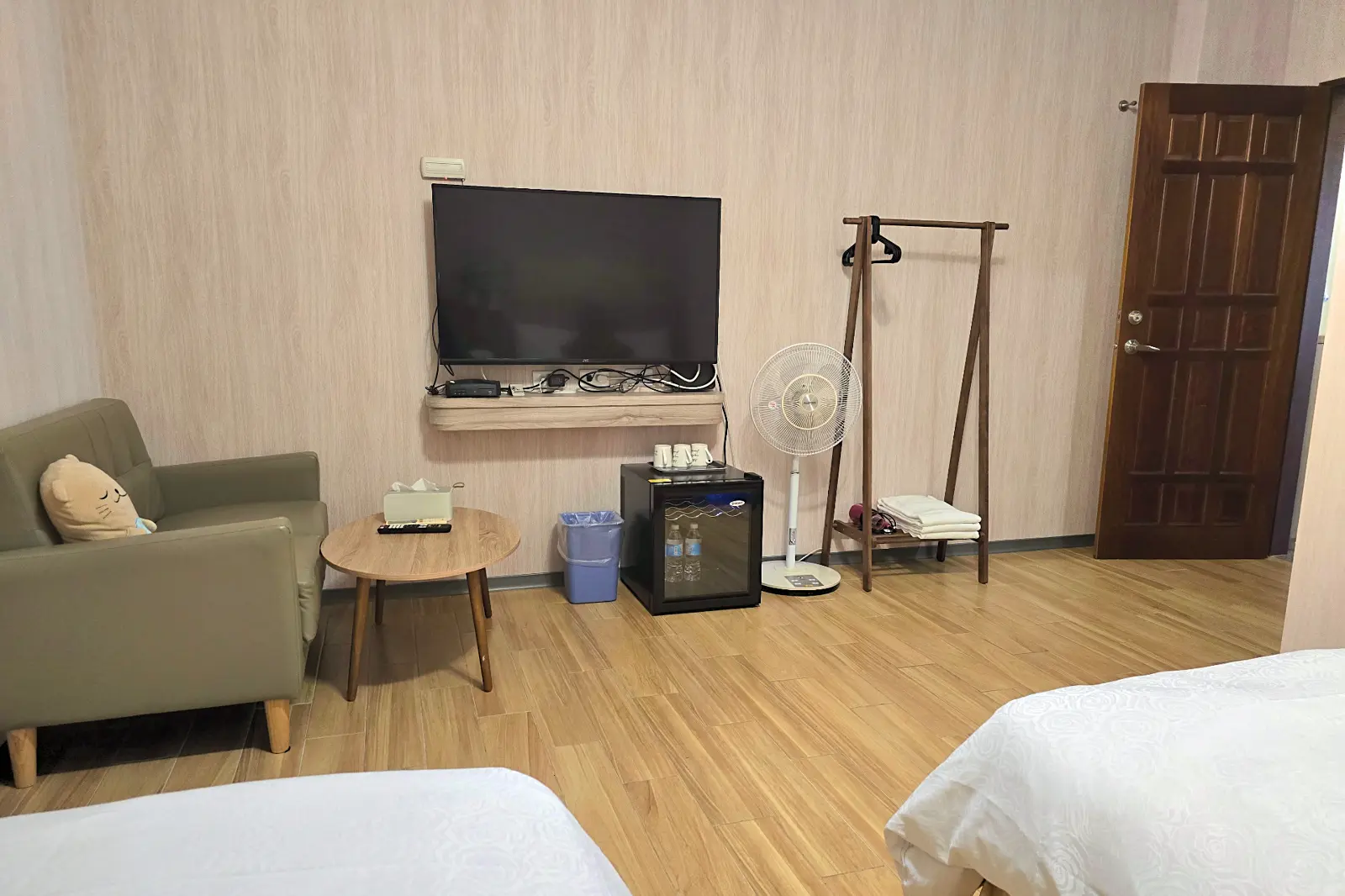 302房電視、小冰箱、衣架與房門入口